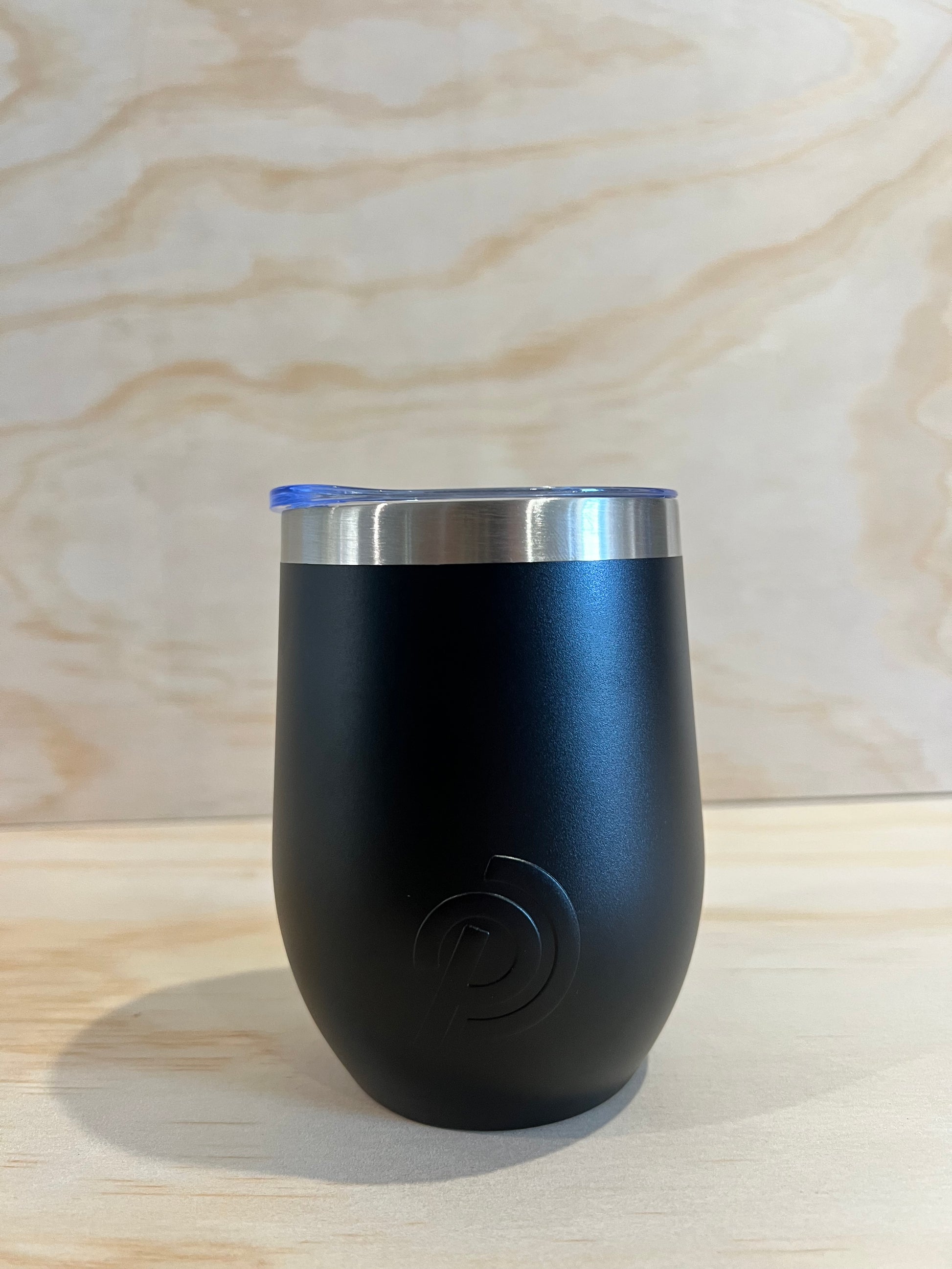 Black and silver cylindrical object on a light wood surface